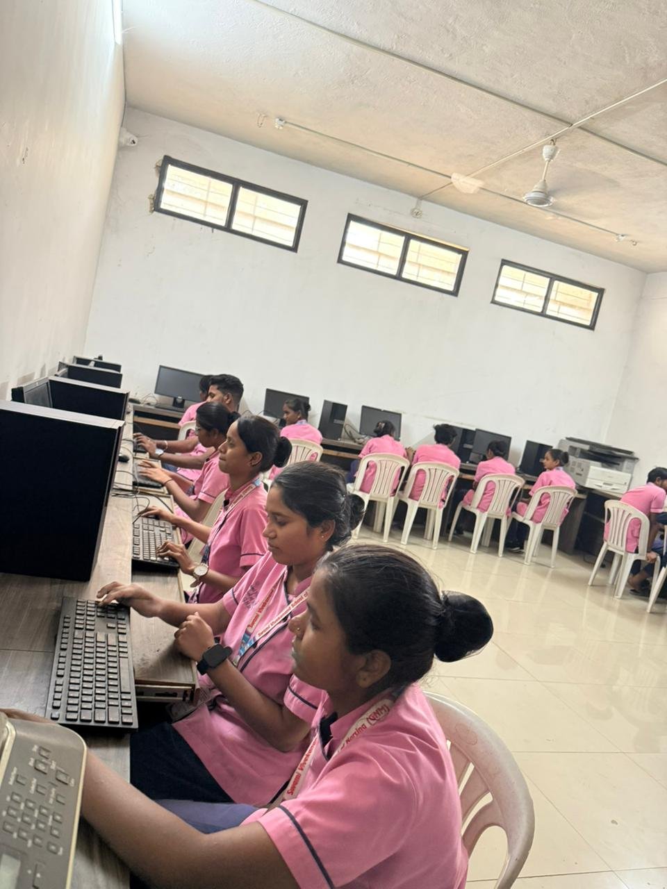 Student at workstation with faculty in background